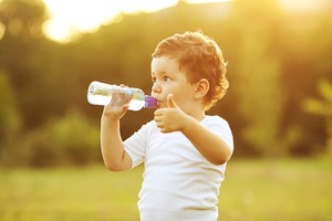 Little boy drinking water. 