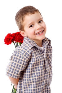 Smiling boy hiding a bouquet