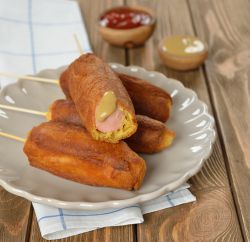 Plate of corn dogs with mustard and ketchup