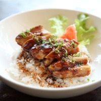 Bowl of orange chicken over rice.