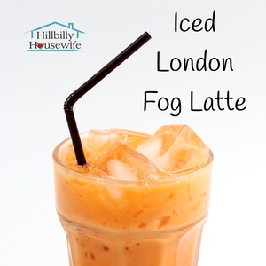 Tall glass of Iced London Fog Latte with a dark straw.. The Hillbilly Housewife Logo is in the background. 